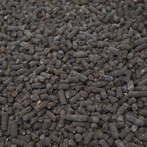 Chicken manure pellets: dark grey-brown cylindrical pellets in a dense layer