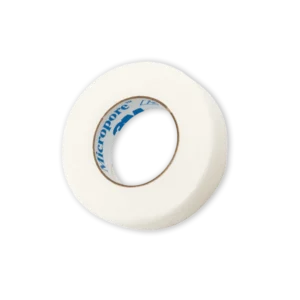 A roll of 3M Micropore breathable white paper tape on a black background