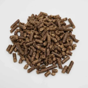 Hardwood pellets: dark brown compressed sawdust cylinders heaped on white