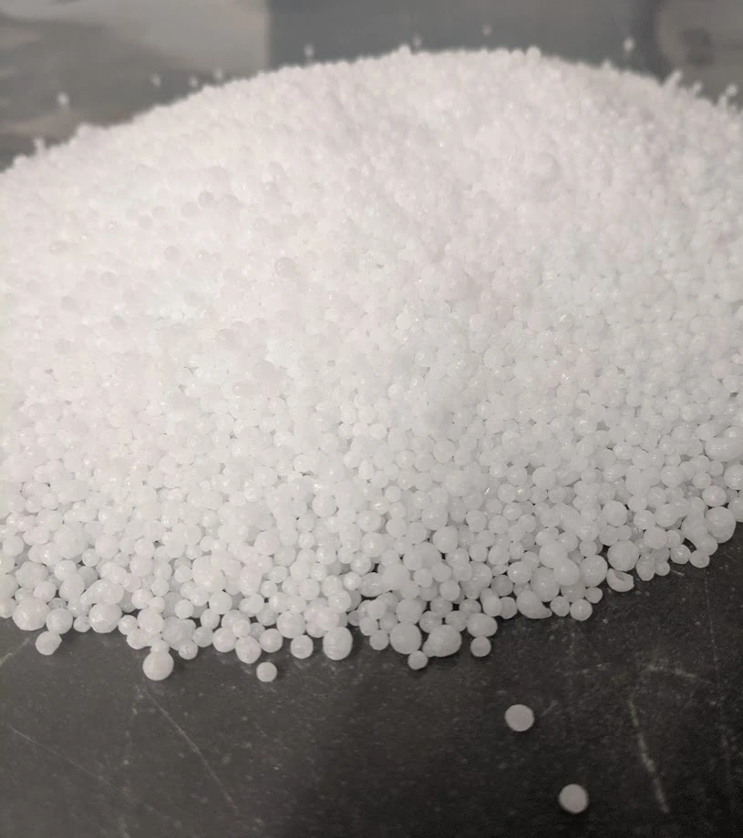 Urea granules: small white spherical pellets heaped on a dark surface