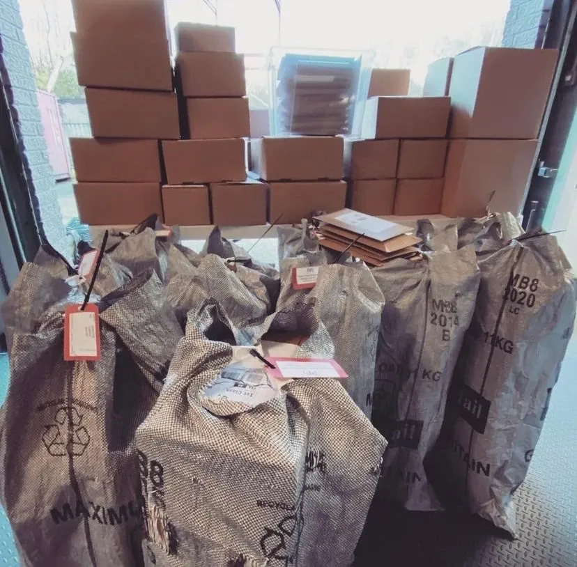 Royal Mail sacks of parcels and stacks of boxes at the door of our unit, ready for collection