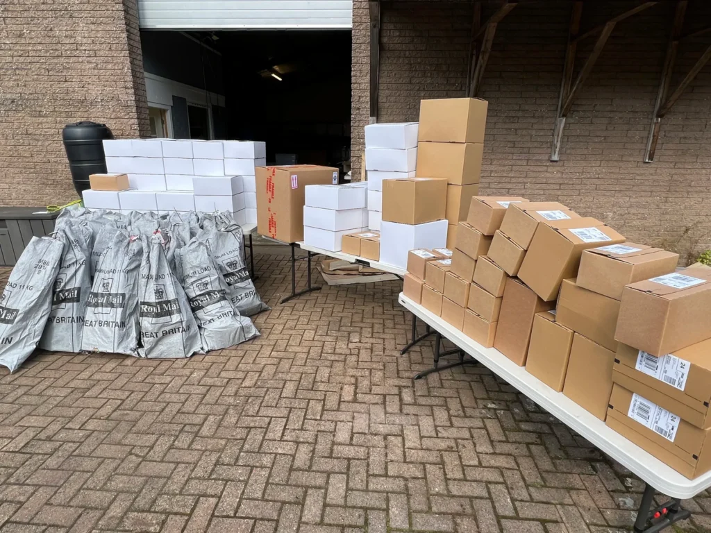 Royal Mail sacks and tables stacked with packed parcels outside our unit, ready for collection