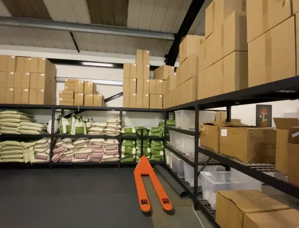 Our stockroom: shelves of substrate bags and boxed stock, with a pallet truck