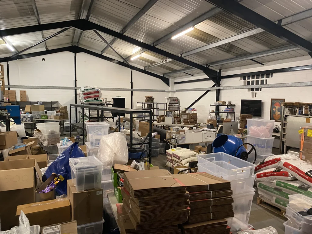 Our unit on moving-in day in December 2021: shelving, tubs, boxes and bags of vermiculite waiting to be unpacked